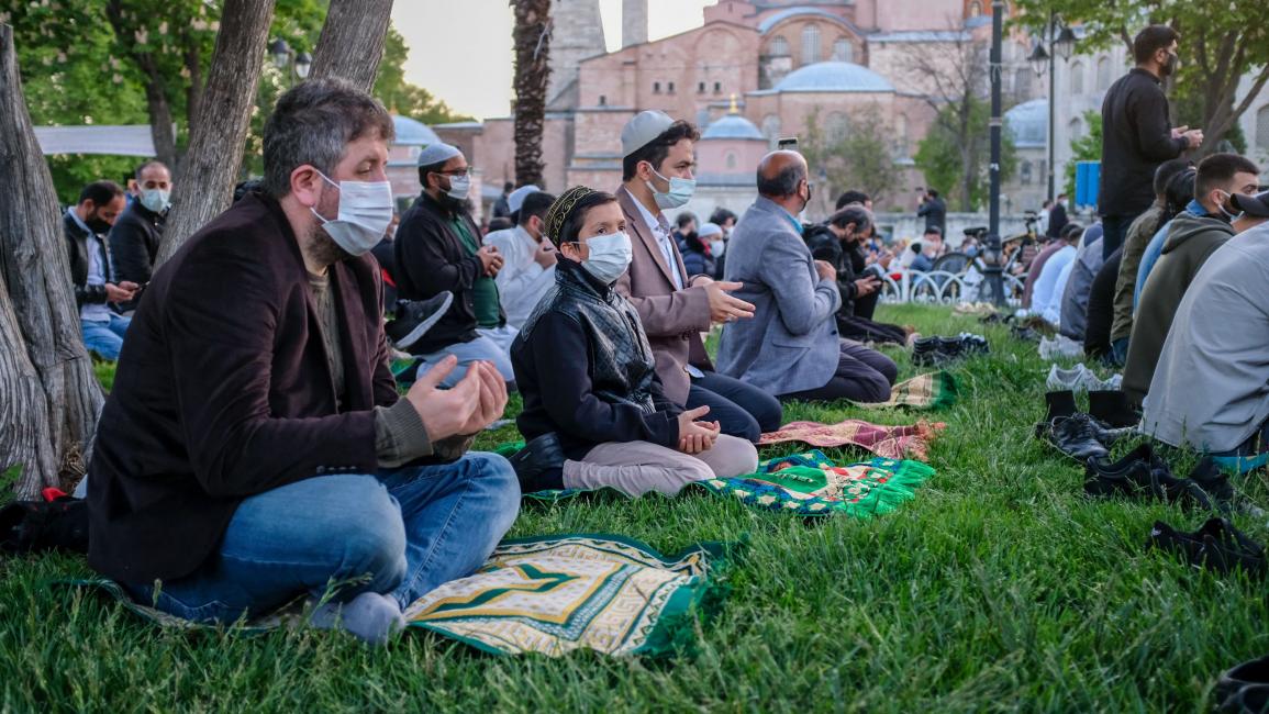 صلاة عيد الفطر خارج مسجد آيا صوفيا الكبير في مدينة إسطنبول التركية اليوم الخميس، في أثناء إغلاق عام بسبب وباء "كوفيد -19" (بولنت كيليتش/فرانس برس)