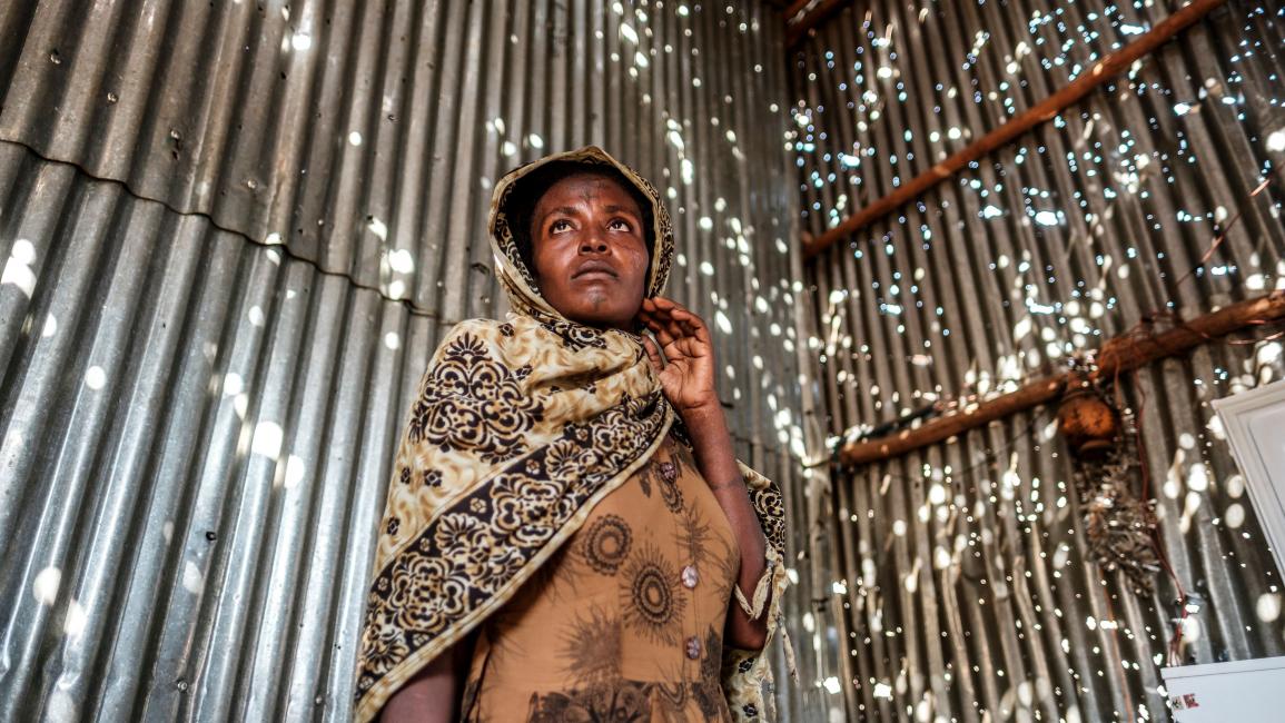 TOPSHOT-ETHIOPIA-TIGRAY-CONFLICT-UNREST TOPSHOT - A woman stands in a metal sheet room that was damaged by shelling, in Humera, Ethiopia, on November 22, 2020. - In that residential compound, two women and an elderly man were killed by shelling and gunfire, while two other women remain on makeshift stretchers as they recover from their wounds. Prime Minister Abiy Ahmed, last year's Nobel Peace Prize winner, announced military operations in Tigray on November 4, 2020, saying they came in response to attacks 