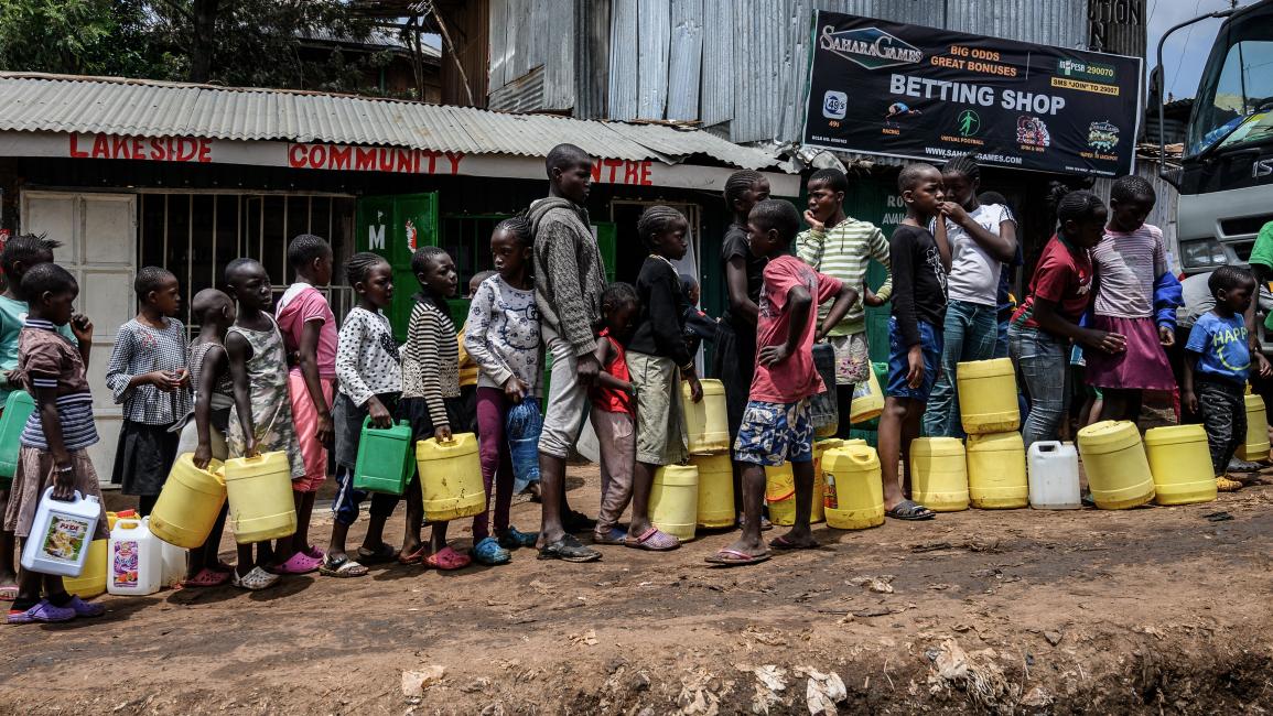 TOPSHOT-KENYA-HEALTH-VIRUS TOPSHOT - Children queue with their jerrycans to fill them with free water distributed by the Kenyan government at Kibera slum in Nairobi, Kenya, on April 7, 2020. - President Kenyatta announced the distribution of free water to low income communiites to curb the spread of the COVID-19 Coronavirus. (Photo by Gordwin ODHIAMBO / AFP) (Photo by GORDWIN ODHIAMBO/AFP via Getty Images)