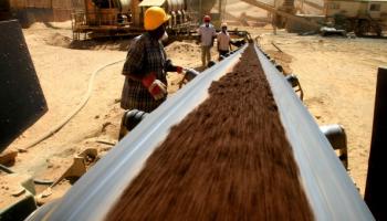 Getty-A Ariab worker watches a belt carrying e