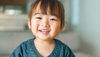 A portrait of a small girl in the living room at home.