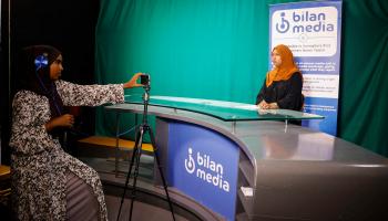 Shukri Mohamed Abdi and Fathi Mohamed Ahmed, journalists at Bilan Media, Somalia's first all-women media team, use a mobile to record the news inside the Bilan Media studios in Mogadishu, Somalia August 20, 2023. REUTERS/Feisal Omar