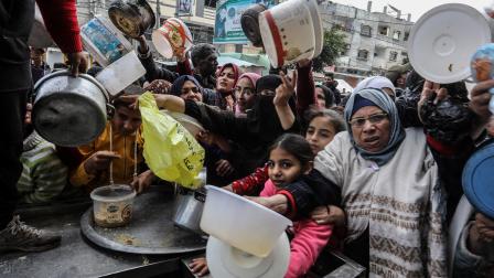 فلسطينيون بأوعية فارغة في غزة (عبد الرحيم الخطيب/الأناضول)